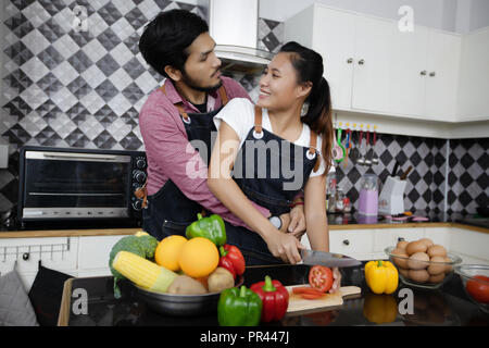 Happy and Smiling young couple cooking food in the kitchen at home Stock Photo