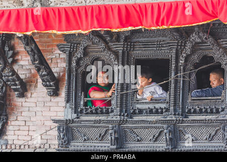 kathmandu,Nepal - Sep 24,2018:Nepalese People watching outside from the artistic wooden window in Kathmandu. Stock Photo