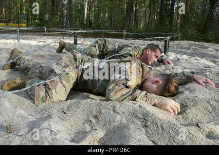 U.S. Soldiers assigned to various units from all over Europe low crawl during an air assault course conducted by an Army National Guard mobile training team from Ft. Benning at 7th Army Training Command's Grafenwoehr Training Area, Germany, Sept. 11, 2018. Stock Photo