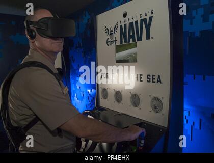 MILLINGTON, Tenn. (Sept. 12, 2018) Commander, Navy Recruiting Command, Rear Adm. Brendan R. McLane had the opportunity to experience the Navy’s Virtual Reality asset, the “Nimitz,” during a scheduled visit to Millington Central High School. The experience consists of going through a series of exercises, starting with a briefing, before participating in a virtual high-speed water extraction of a Navy SEAL team that is pinned down under enemy fire. The Nimitz is named after Fleet Adm. Chester Nimitz, a native of Fredericksburg, Texas, who commanded the U.S. Pacific Fleet during WWII. Stock Photo