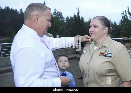 Wash. (Sept. 14, 2018) - Chief Mass Communication Specialist Gretchen Albrecht, a native of Chino Hills, Calif., is pinned with her chief petty officer (CPO) anchors by her father, husband, and sons during Naval Hospital Bremerton's (NHB) CPO pinning ceremony. During the ceremony, five Sailors from NHB received their anchors. Stock Photo