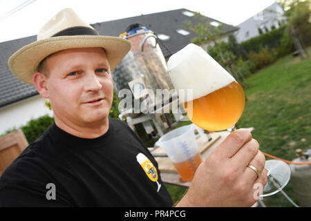 20 September 2018, Mecklenburg-Western Pomerania, Greifswald: German amateur brewer Jan Evermann holding a glass of his own home-brewed beer in Greifswald, Germany. Photo: Stefan Sauer/dpa Stock Photo