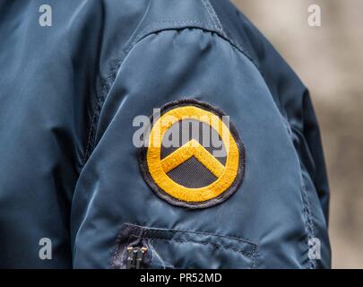Garmisch Partenkirchen, Bavaria, Germany. 29th Sep, 2018. Logo of the Identitaere Bewegung worn by a person that appeared to be working in a security capacity at the Compact Konferenz in Garmisch Partenkirchen. Adding themselves to the 'who's who'' list of of several hundred right-extremists from Germany, Austria, Switzerland, and other countries, Tommy Robinson, founder of the British EDL, Lutz Bachmann, grounder of Germany's Pegida, and Martin Sellner of the Identitaere Bewegung were guests as the Compact Konferenz held in the international tourist town of Garmisch Partenkirchen