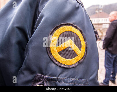 Garmisch Partenkirchen, Bavaria, Germany. 29th Sep, 2018. Logo of the Identitaere Bewegung worn by a person that appeared to be working in a security capacity at the Compact Konferenz in Garmisch Partenkirchen. Adding themselves to the 'who's who'' list of of several hundred right-extremists from Germany, Austria, Switzerland, and other countries, Tommy Robinson, founder of the British EDL, Lutz Bachmann, grounder of Germany's Pegida, and Martin Sellner of the Identitaere Bewegung were guests as the Compact Konferenz held in the international tourist town of Garmisch Partenkirchen