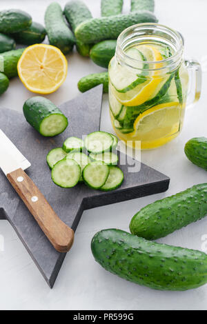 cutting Board in the form of stars. Summer cocktail cucumber lemonade. Refreshing water with cucumber, mint and lemon on grey background. Healthy drink and detox concept. Copy space Stock Photo