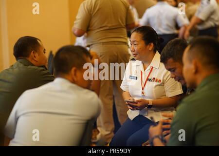 Hawaii Army National Guard, Maj. Lauren Sodetani-Yoshida, talks strategy with her counterparts from the Tentara Nasional Indonesia on the second day of Gema Bhakti as the focus of the staff planing exercise shifted from academic to execution, Sept. 18, 2018, Jakarta Indonesia. Gema Bhakti is a joint force multi-national staff exercise where military staff from the U.S. Indo-Pacific Command and Indonesia work through a process known as the military decision making process. This process is a crucial step that involves the commander’s staff working with with all the higher and lower commands to d Stock Photo