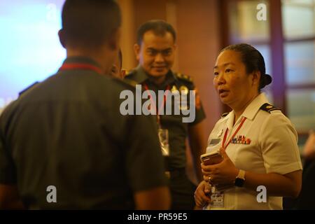 Hawaii Army National Guard, Maj. Lauren Sodetani-Yoshida, talks strategy with her counterparts from the Tentara Nasional Indonesia on the second day of Gema Bhakti as the focus of the staff planing exercise shifted from academic to execution, Sept. 18, 2018, Jakarta Indonesia. Gema Bhakti is a joint force multi-national staff exercise where military staff from the U.S. Indo-Pacific Command and Indonesia work through a process known as the military decision making process. This process is a crucial step that involves the commander’s staff working with with all the higher and lower commands to d Stock Photo