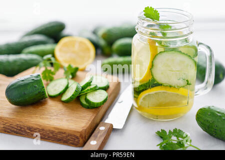 Summer cocktail cucumber lemonade. Refreshing water with cucumber, mint and lemon on grey background. Healthy drink and detox concept. Copy space Stock Photo