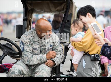 Chief Master Sgt. Elvin Young, 374th Airlift Wing command chief, introduces himself to a family during the Japanese-American Friendship Festival at Yokota Air Base, Japan, Sept. 15, 2018. The festival gives community members a chance to come onto Yokota to see static aircraft, witness military demonstrations, learn about the capabilities and training done at Yokota and to meet with the US and Japan Self-Defense Force members who work and live on base. (Senior Airman Gabrielle Spalding) Stock Photo