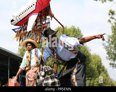 London, UK - August 27, 2018:  Notting Hill Carnival Young artists on stilts posing against the blue sky Stock Photo