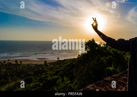 Vagator Beach - Sunset rays captured in the frame around the green natural beauty of Goa, India. Stock Photo