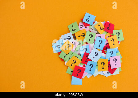 Too Many Questions. Pile of colorful paper notes with question marks on yellow background. Closeup. Stock Photo