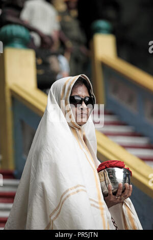 Female kavadi bearer standing on Batu Caves steps during Thaipusam festival in Selangor, Malaysia Stock Photo