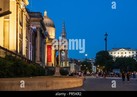 London, England - August 4, 2018: Evening side-view of the National Gallery at Trafalgar Square, London, as people stroll by. Stock Photo