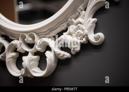 Expensive interior. Stucco elements on a mirror. White patterned. Mouldings element from gypsum or plastic. Roccoco style Stock Photo