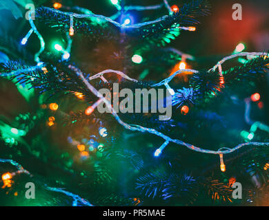 festive background multicolored christmas lights on new year tree Stock Photo