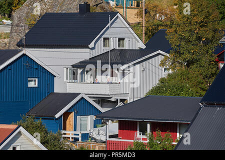 A Couple Sit In The September Sun On Their Balcony In Øksfjord, High Above The Norwegian Arctic Circle, Finnmark County, Norway. Stock Photo
