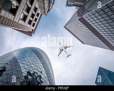 London in the UK. Top of iconic buildings with airplane flying over them Stock Photo
