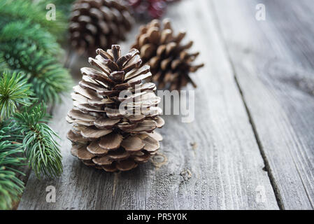 Christmas concept: pine cones and spruce branches on the background of old unpainted wooden boards, with copy-space Stock Photo