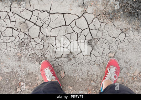 man standing on dry cracked soil Stock Photo