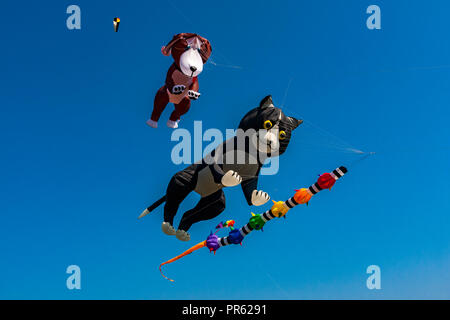 Novelty animal kites being flown against a deep blue sky Stock Photo