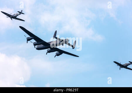Lancaster Bomber and two Spitfire planes formation memorial flight at WW2 day. Stock Photo