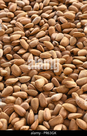 vertical image full frame shelled almonds image shot in selective focus to ad copy space blurred background top and bottom Stock Photo