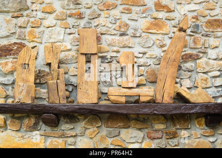 Wooden made construction objects on a stone wall. Background Stock Photo