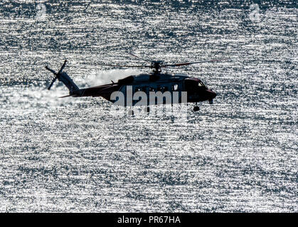 HM Coastguard rescue helicopter G-MCGY during a rescue operation on the coast of Lundy island off North Devon UK Stock Photo