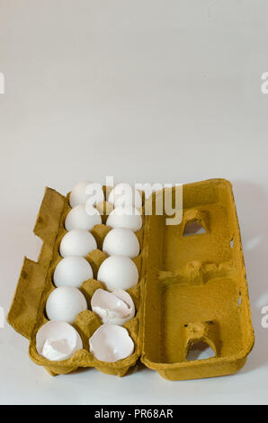 Box with twelve white eggs, 3 broken eggs on an isolated white background. food ingredient, healthy breakfast. Stock Photo