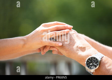 Close-up Of A Woman Holding Her Father's Hand At Outdoors Stock Photo