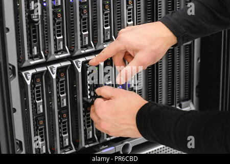 Male Technical Consultant Installing Blade Server In SAN At Data Stock Photo