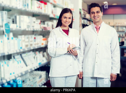 Two happy friendly pharmacists working in luxury pharmacy Stock Photo