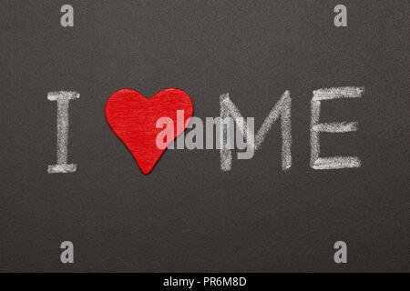 Self-loving concept made with red heart and handwritten text I Love Me with white chalk on blackboard. Stock Photo