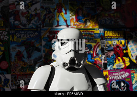 Madrid, Spain - November 30, 2014: Head shot of a white Imperial Stormtrooper action figure against a colorful wall, covered with old Marvel comics. Stock Photo