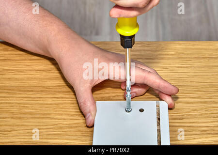 Furniture assembler uses connecting dowel pin, close-up. Stock Photo