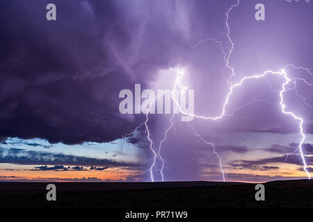 Lightning bolts strike from a storm at sunset near Holbrook, Arizona Stock Photo