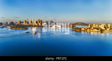 Smooth calm waters of Sydney Harbour cut by passenger ferries to the city CBD in Sydney with major Australian landmarks on both shores connected by th Stock Photo