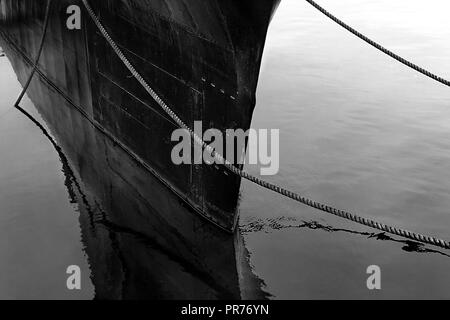 Very minimalistic picture in black and white showing a large submarine docked in the river Stock Photo