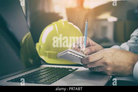 Engineer is making plan on blank notebook in office Stock Photo