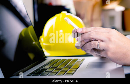 Engineer is using mobile phone in office Stock Photo