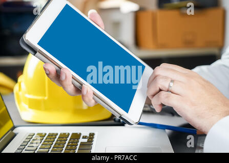 Engineer holding a blank tablet screen for tablet engineering application mock up Stock Photo
