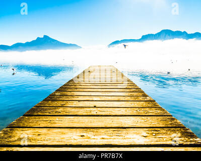 View on morning fog on Pier of lake Mondsee and Alps in Austria Stock Photo