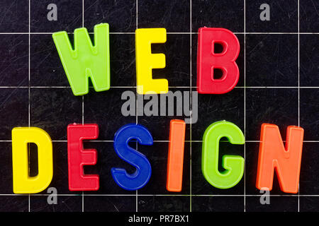 Web Design text with magnetic colorful letters on blackboard Stock Photo