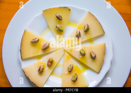 Manchego cheese with pistachios and olive oil. La Mancha, Spain. Stock Photo