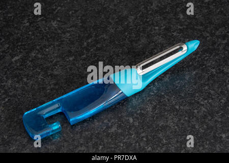 Two shade of blue plastic potato peeler on a dark background Stock Photo