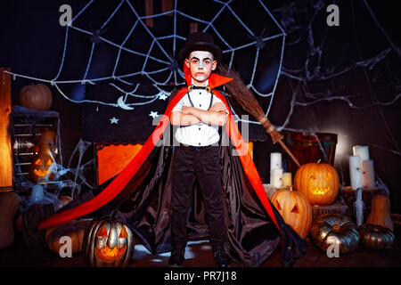 Portrait of a boy dressed in a costume of a vampire over grunge background. Halloween party. Stock Photo