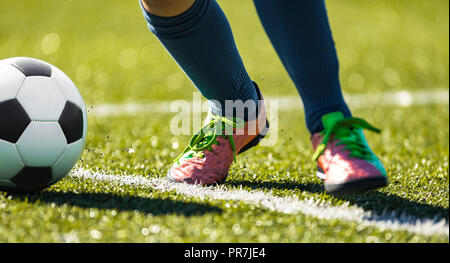 Close up soccer football kick the ball. Feet of footballer running and kicking the soccer ball on green grass Stock Photo