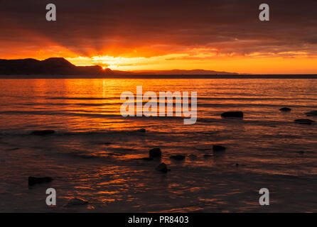 Lyme Regis, Dorset, UK. 30th September 2018.  UK Weather: The sky glows orange over the Jurassic Coast as the rising sun bathes the sky and sea with with rays of early morning sunshine. Credit: Celia McMahon/Alamy Live News Stock Photo