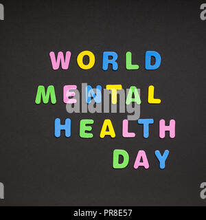 Creative colorful text made from plastic letters World Mental Health Day writing on black paper background with copy space. Holiday message concept, c Stock Photo
